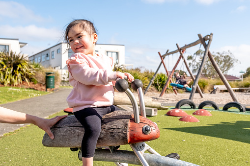 A toddler playing on a seesaw