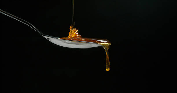 istock Honey Flowing in a spoon against Black Background 1688332634