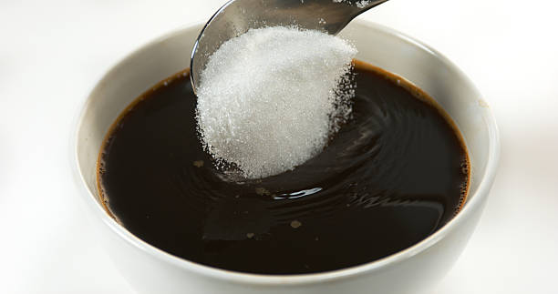 istock Sugar Falling into Bowl of Coffee against White Background 1688333179