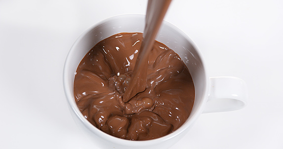 Chocolate Pouring into a Bowl against White Background
