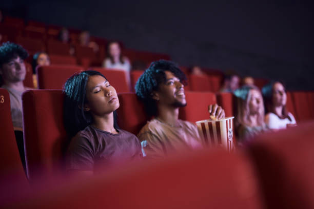 Asian woman fell asleep during movie projection in cinema.