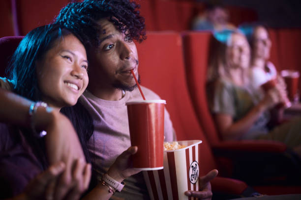 Embraced couple enjoying in a movie in theatre.