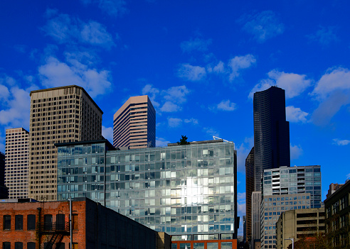 Seattle, Washington state, United States: skyscrapers in the financial district - Seattle is the largest city in the northwestern United States, it is the administrative seat of King County. Green façade of Griffis Seattle Waterfront in the center, Docusign / Wells Fargo above it, Columbia Center to the right and Henry M. Jackson Federal Building to the left.