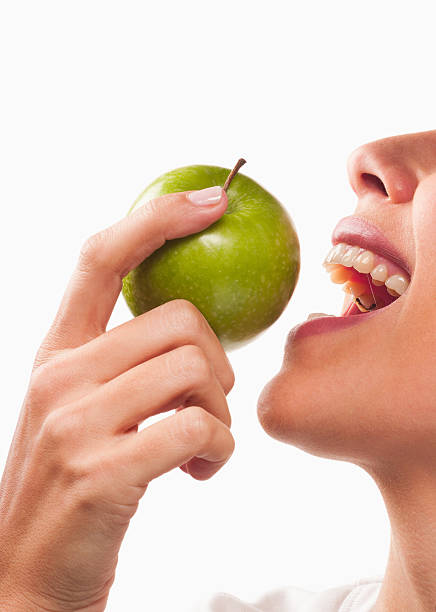 sonriente mujer comiendo manzana verde - apple women green eating fotografías e imágenes de stock