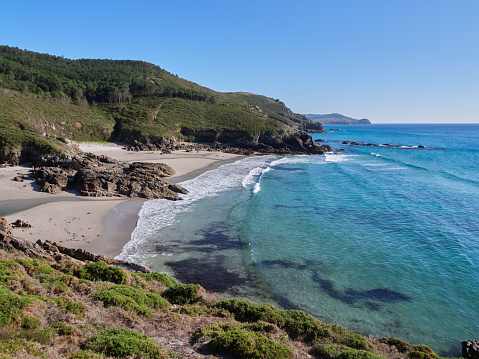 Costa da Morte beach on the Atlantic Ocean on a summer day with calm sea. This region of northern Spain is known for its unspoiled coastline and surfing waves.