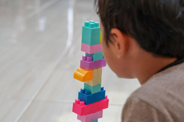 istock Young asian boy playing & building with colorful plastic bricks or toy block 1688404450