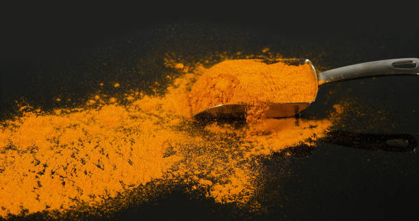 istock Turmeric, curcuma longa, Powder falling against Black Background, Indian Spice 1688414658