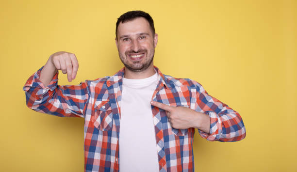 istock Handsome happy man indicating empty space isolated on yellow background. 1688418662