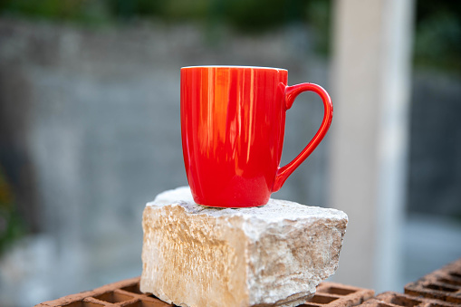 Red coffee cup on stone, close up