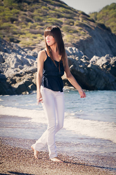 istock Young Woman Walking on the Beach 168842713