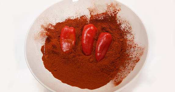 Paprika, capsicum annuum, falling into a bowl against White Background