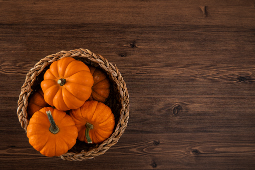 Top view of colorful pumpkins on brown wooden background