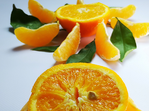 Experience the vibrant allure of a cut orange slice, illuminated by indoor sunlight. This captivating image showcases the radiant beauty of this citrus delight.