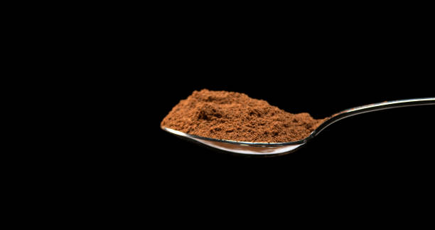 istock Nutmeg, myristica fragans, Powder falling from Spoon against Black Background 1688441395