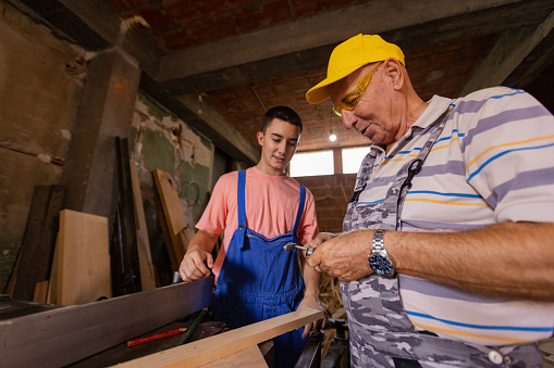 The passing of knowledge and love for carpentry between generations in a family-owned woodshop.