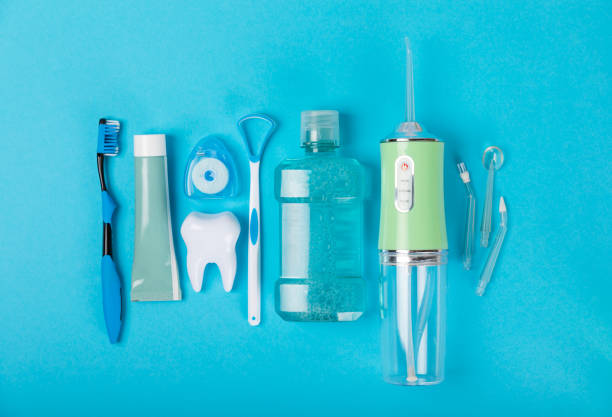 istock Electronic oral irrigator, toothbrush, paste, dental floss and mouthwash on a blue background. Dental tool for oral hygiene. Electric Interdental Cleaner. Dental water shower. Oral care concept. 1688480614