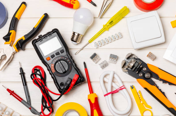 istock Electrician tools on  background.Multimeter,construction tape,electrical tape, screwdrivers,pliers,an automatic insulation stripper, socket and LED lamp.Flatley.electrician concept. 1688486037