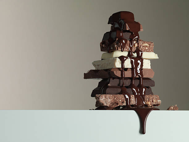 gouttes de sirop de chocolat sur une pile de chocolat et bars - petite faiblesse photos et images de collection