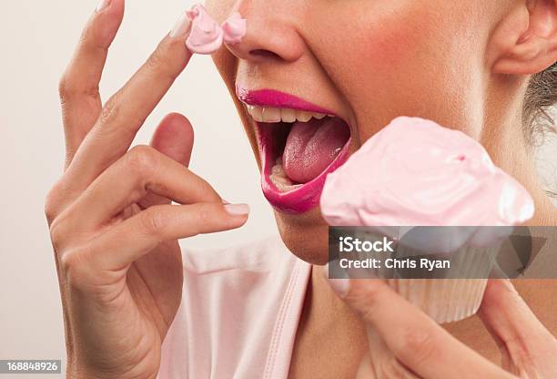 Kobieta Z Różowa Szminka I Frosting Na Nos Jedzenie Cupcake - zdjęcia stockowe i więcej obrazów Jeść