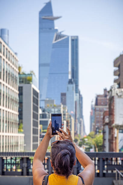 donna che scatta una foto di un grattacielo - new york state new york city vanishing point national landmark foto e immagini stock