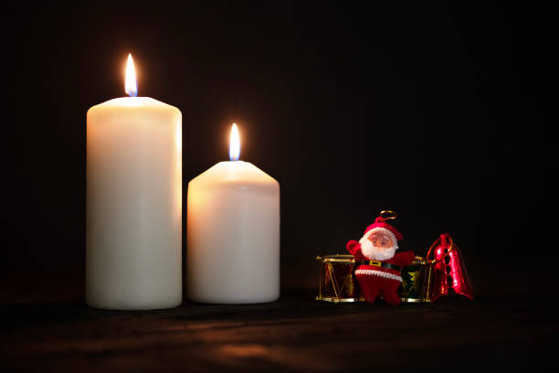Burning candles and christmas decorations on a dark background.