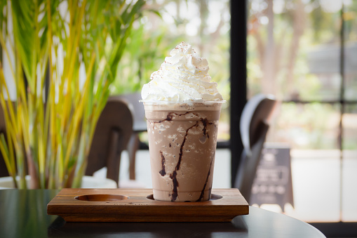 istock Mocha frappuccino in plastic cup with whipping cream on top. Coffee blended with chocolate. Closeup shot in cafe. 1688511611