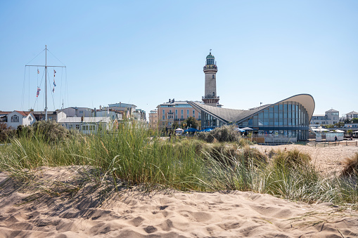 Rostock Warnemünde, Mecklenburg-Western Pomerania, Germany - September 9, 2023: View of the lighthouse and teapot on the beach with dunes on the day in summer.