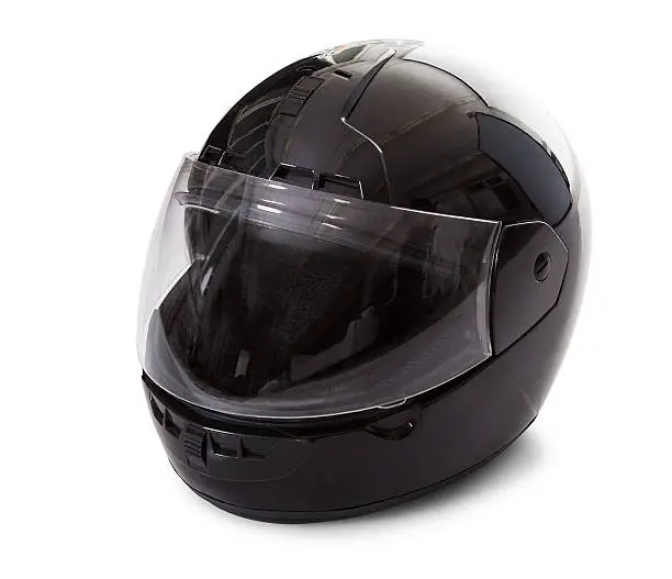 Studio image of a black motorcycle helmet with the visor closed on a white background