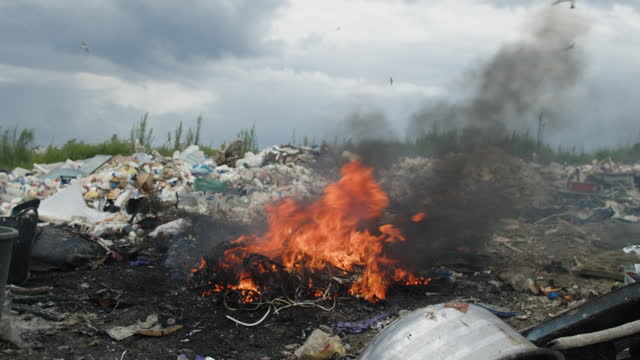 Garbage burning at a landfill. Environmental damage, air and water pollution and ecology crisis concept.