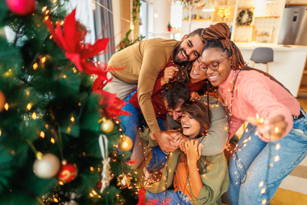 istock Friends having fun decorating Christmas tree 1688539917