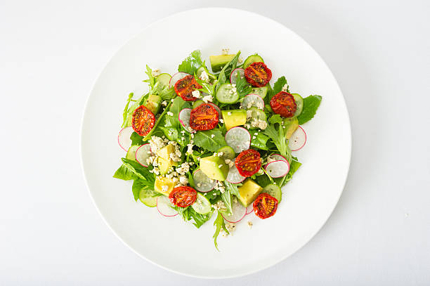 Gourmet Salad Gourmet fresh salad with organic greens, oven dried tomatoes, radish,avocado,cucumber and crumbled goats cheese arugula photos stock pictures, royalty-free photos & images