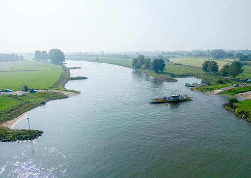 Ferry service between the town of Dieren and Olburgen over the river IJssel. Drone point of view.