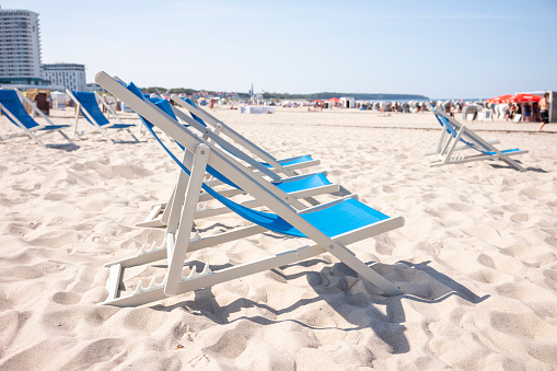 Rostock Warnemünde, Mecklenburg-Western Pomerania, Germany - September 9, 2023: Blue sun loungers on the beach with a view of the Hotel Neptun on a summer day.
