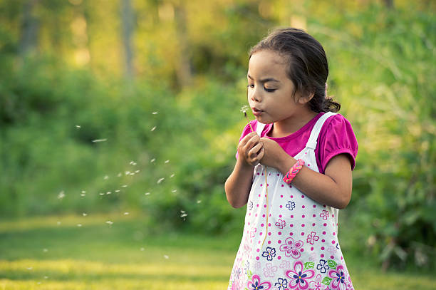 istock Girl Blowing Dandelion Seeds 168856070
