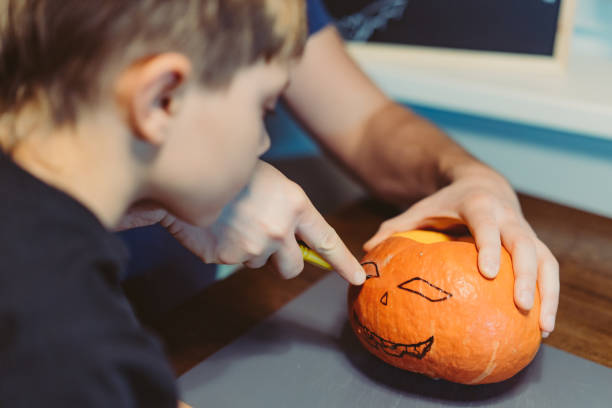 istock Children with father carving a traditional Jack lantern from pumpkin 1688563985