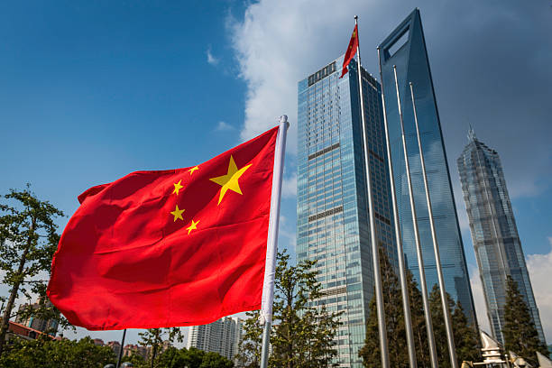 Chinese flag flying beside futuristic Shanghai skyscrapers stock photo