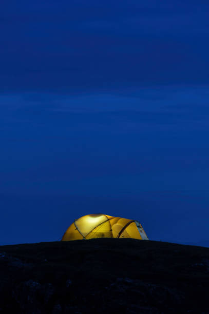 istock Yellow dome tent illuminated on mountain at night 168857814