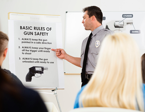 An instructor teaching a gun safety class to a group of students.