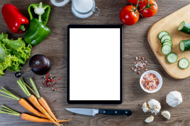 istock Vegetables and ingredients on wooden table background, cooking concept, top view, tablet 1688579988