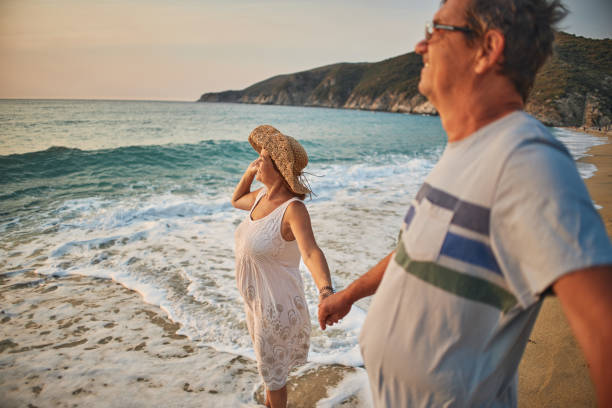istock Senior couple enjoying walking along the beach 1688591902