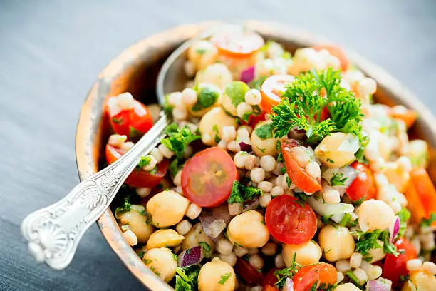 A chickpea and pearl couscous salad mixed with tomatoes, onions and herbs.
