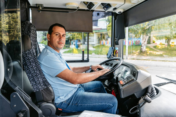 un homme adulte conduit un autobus dans la rue - traffic car street parking photos et images de collection