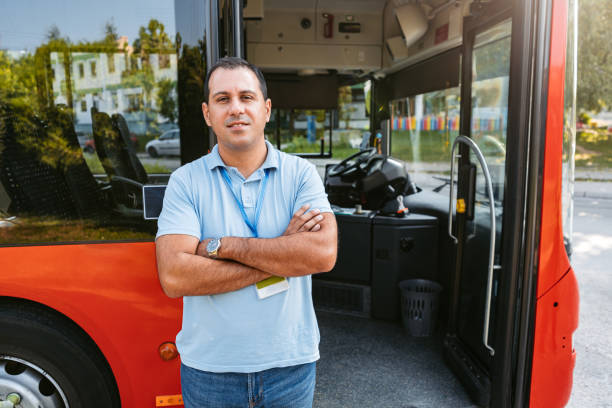 chauffeur de bus mid adult debout devant un bus - traffic car street parking photos et images de collection