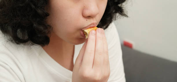 istock Young asian girl eating snack 1688607962