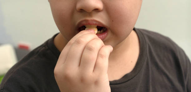 istock kid teeth hold candy in mouth 1688607990