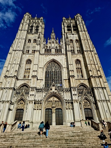 The Cathedral of St. Gudula (Cathedral of St. Michael and St. Gudula) in Brussels. It is a medieval Roman Catholic cathedral in central Brussels, Belgium. The church was built between 11th–15th centuries. The image shows the church facade and and a nearby blue sky.