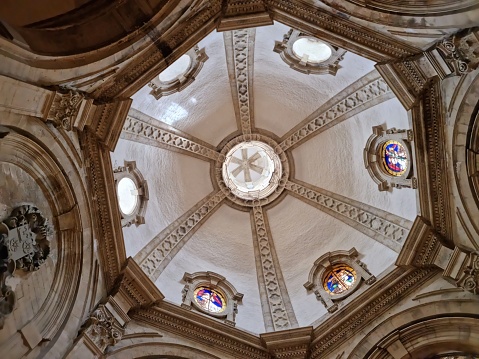 Inside the famous Cathedral of St. Gudula (Cathedral of St. Michael and St. Gudula) in Brussels. It is a medieval Roman Catholic cathedral in central Brussels, Belgium. The church was built between 11th–15th centuries. The image shows some columns and the ceiling of the chruch.