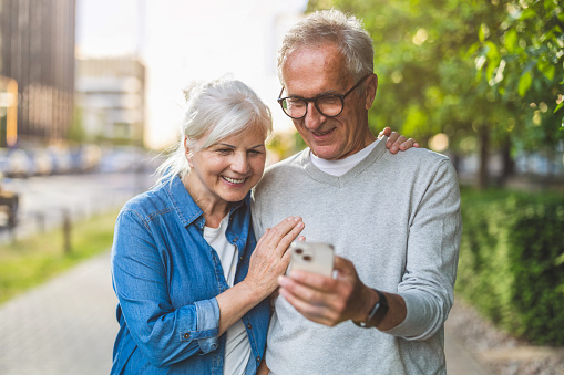 Senior couple using smartphone in the city