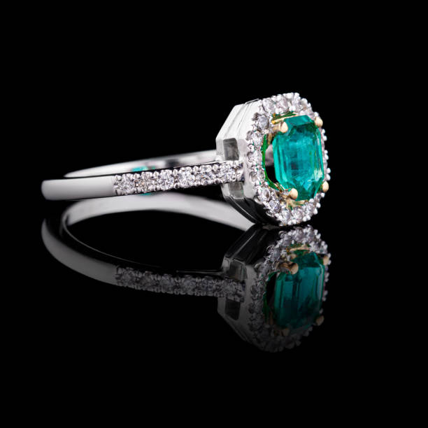 istock beautiful white gold ring with diamonds and emerald on a black background 1688643579