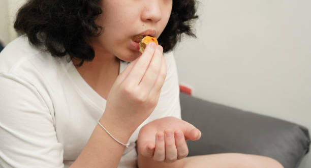 istock Young asian girl eating snack 1688673836